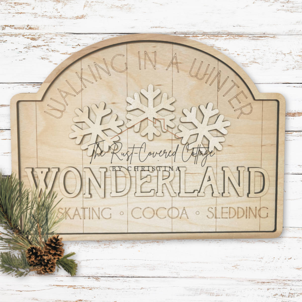 Unfinished Winter Wonderland Sign with layered snowflakes and lettering on white distressed boards beside greenery