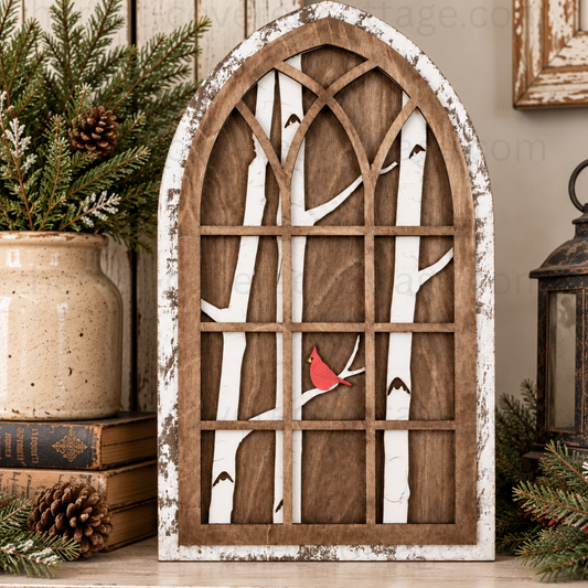 Finished Arched Cardinal Window featuring a distressed white arched frame, rustic brown wood, white birch trees, and a red cardinal, styled on a farmhouse shelf with winter greenery and an unlit lantern.