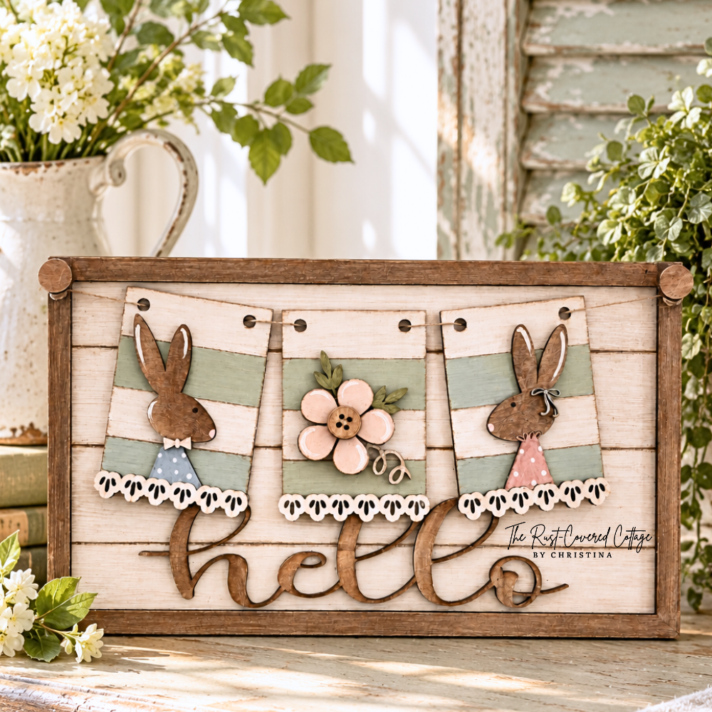 Finished Bunny Couple & Spring Blooms interchangeable banner featuring two wood bunnies, a layered flower, sage green stripes, and a rustic Hello sign base styled in a bright vintage cottage setting.