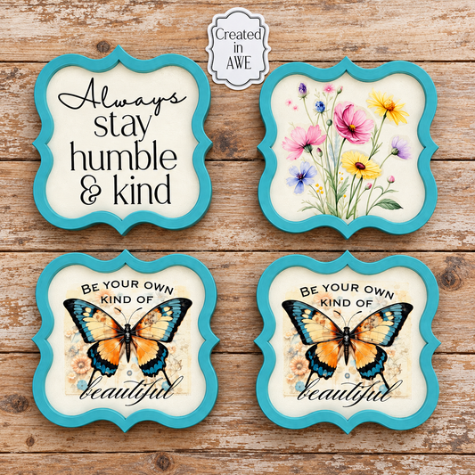 Set of four aqua framed coasters featuring floral, inspirational, and butterfly designs displayed on a worn wood background.