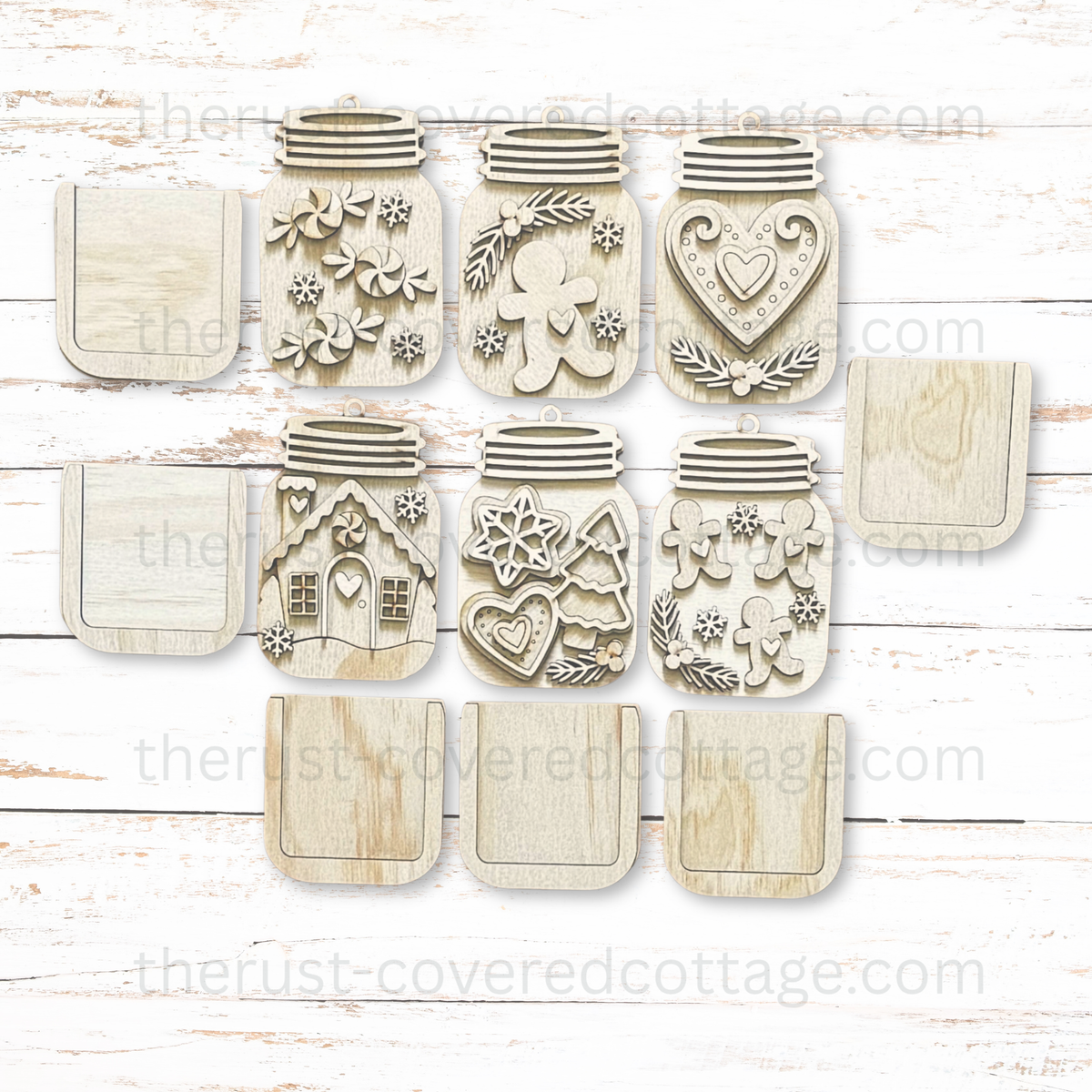 Six unfinished gingerbread mason jar ornaments with gingerbread figures, a house, peppermints, hearts, snowflakes, and separate gift card holder pieces.