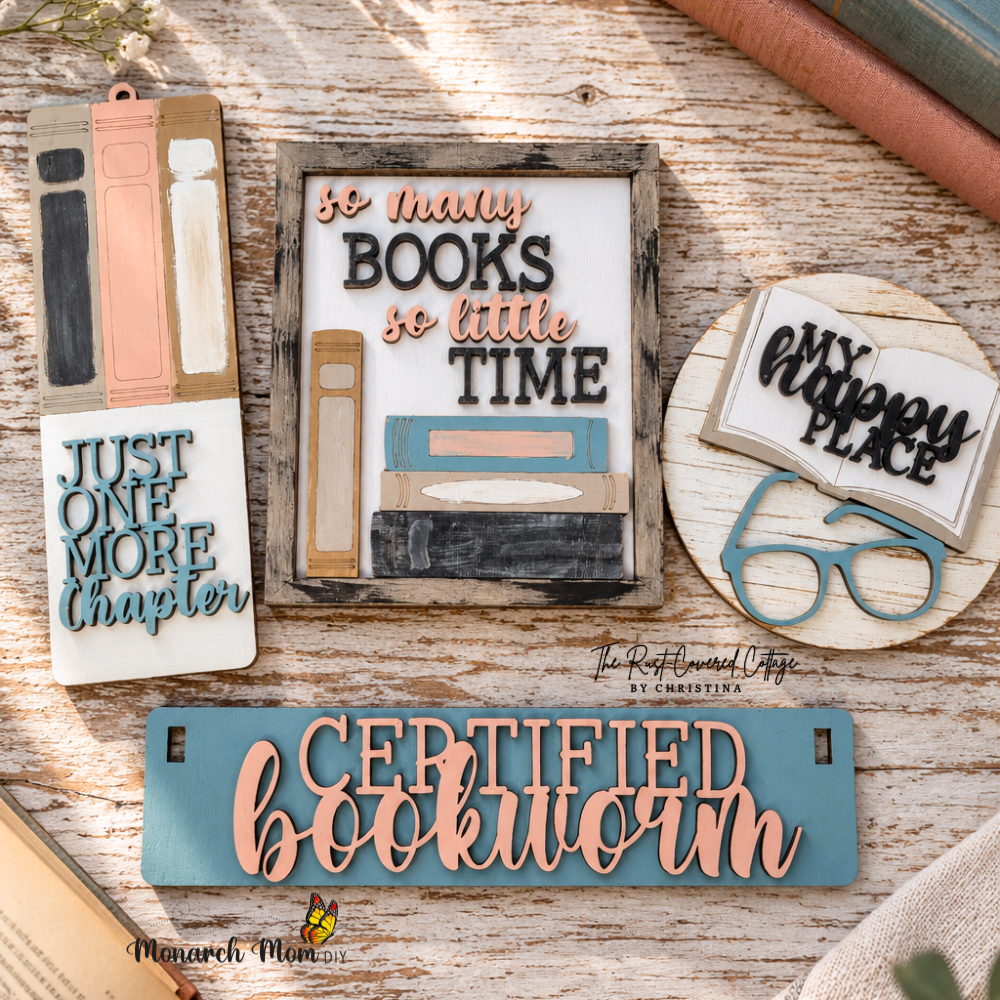 Finished Certified Bookworm wagon insert pieces arranged in a flat lay with book-themed signs, glasses, and vintage-style books on a worn wood surface.