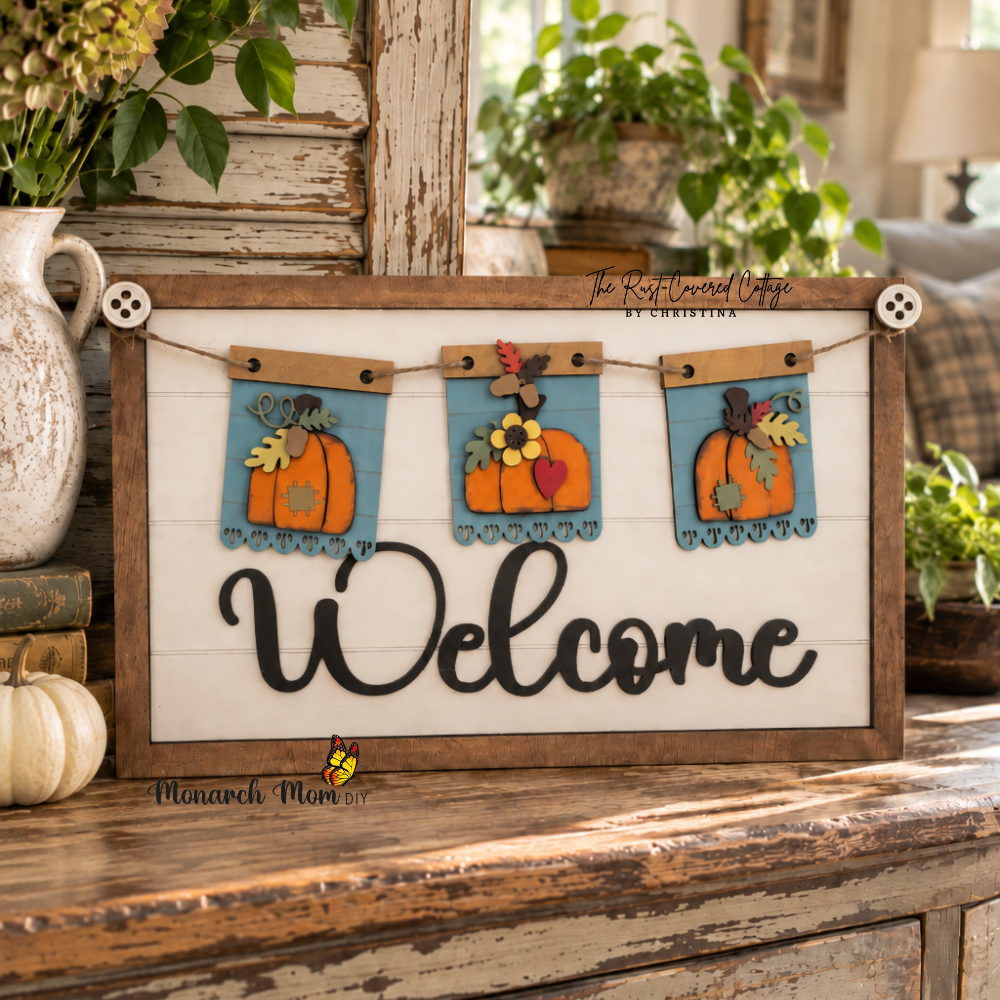 Finished Welcome interchangeable sign featuring three fall pumpkin banner inserts, displayed on a distressed vintage cabinet in a bright, collected cottage-style interior.